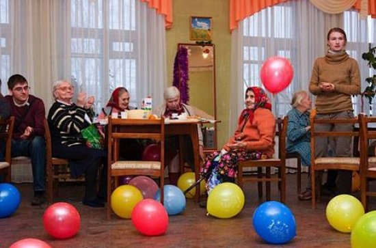 старенькие люди за столами, по всей комнате летают шарики