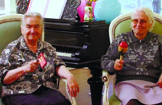 бабушки сидят в креслах и играют на музыкальных инструментах